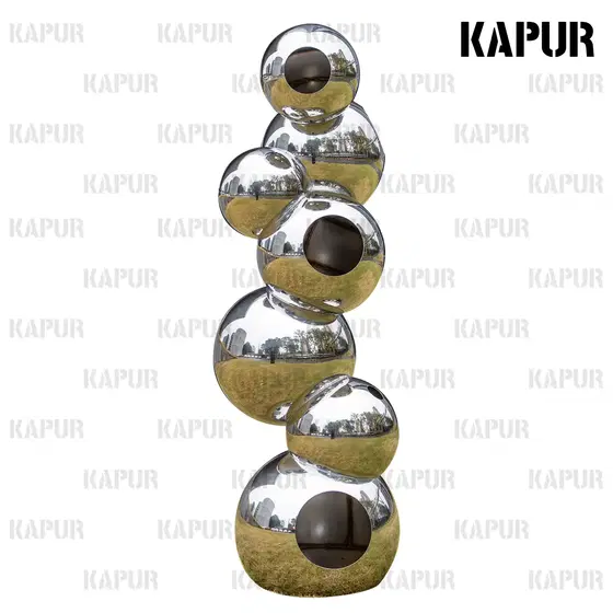 Mirror-polished stainless steel sphere sculpture standing on a paved outdoor plaza