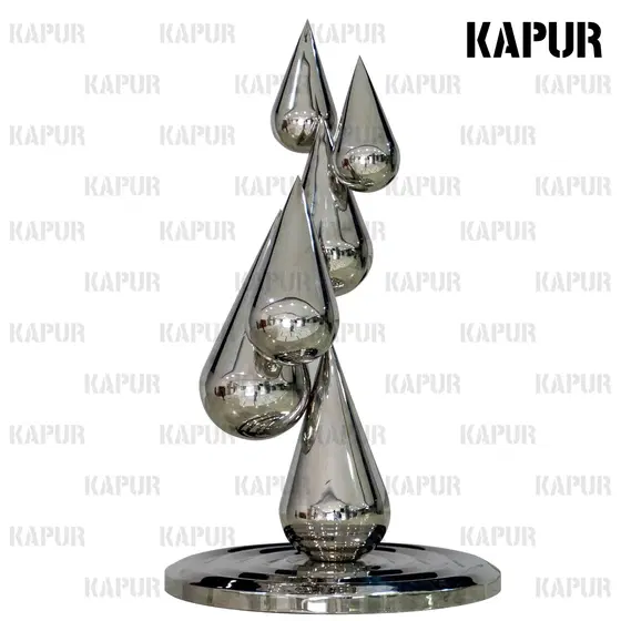 Polished stainless steel water drop sculpture standing on a paved outdoor plaza with reflective surface catching sunlight