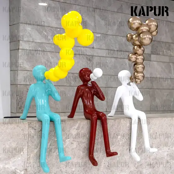 Fiberglass sculpture of a figure blowing bubbles standing in a modern garden plaza