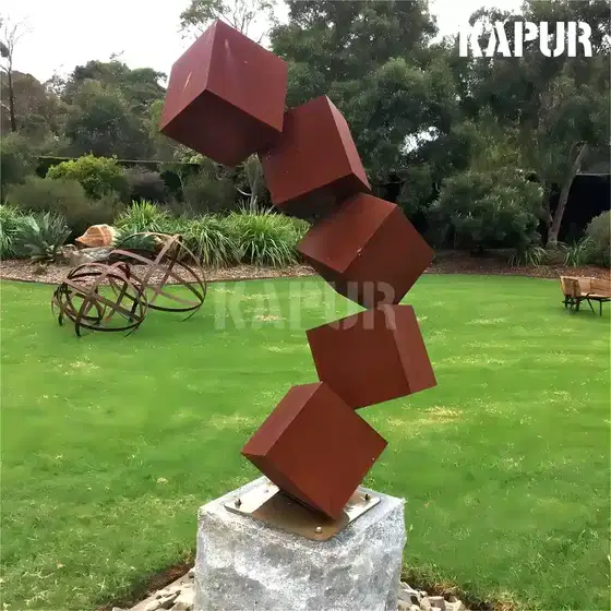 Large corten steel sculpture in a garden setting, showing the natural rust patina and organic form