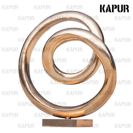 Polished stainless steel Möbius ring sculpture standing on a paved outdoor plaza, reflecting the sky and surrounding architecture