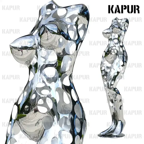 Polished stainless steel hollow woman sculpture standing on a paved outdoor plaza, viewed from the front