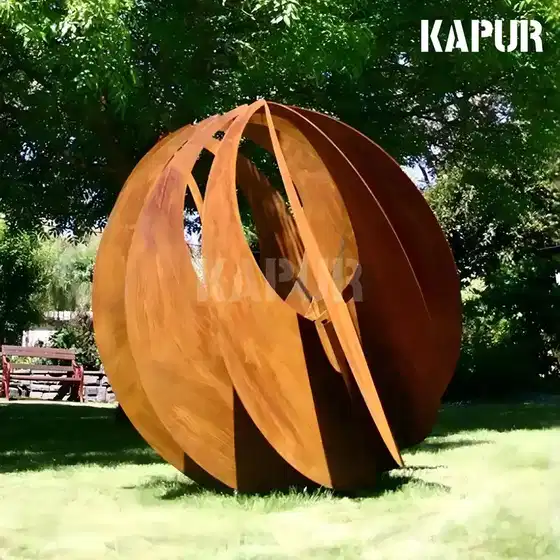 Abstract corten steel spherical sculpture standing in a garden setting with natural planting around it