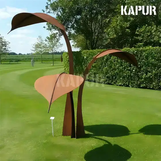 Corten steel leaf sculpture standing in a garden setting with plants and natural light