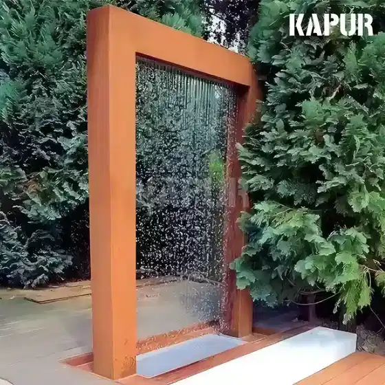 Corten steel sculpture with rain screen and water feature in an outdoor garden setting, showing natural rust patina and curved form