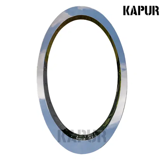 Slant-cut circular stainless steel sculpture standing in a modern garden landscape with reflective surface catching sunlight