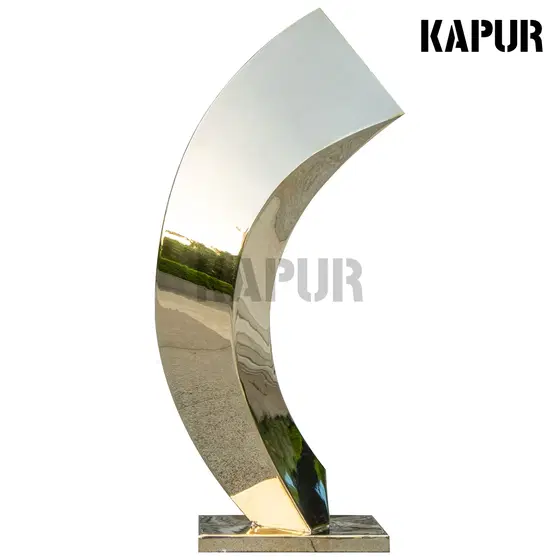 Polished stainless steel art sculpture standing in a modern interior space with reflective surface