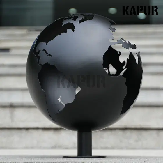 Black openwork stainless steel garden sculpture standing in a modern outdoor garden with reflective polished surface