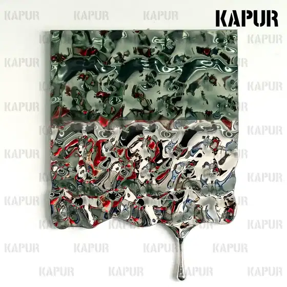 Corrugated stainless steel wall sculpture with flowing water form mounted on a modern building facade