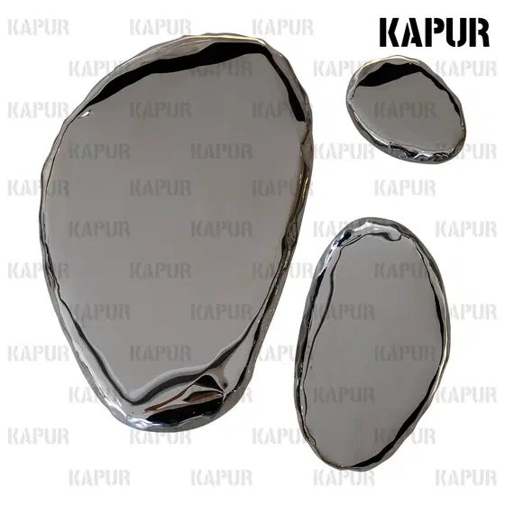Polished stainless steel pebble-shaped wall sculpture mounted on a modern interior wall with reflective surface