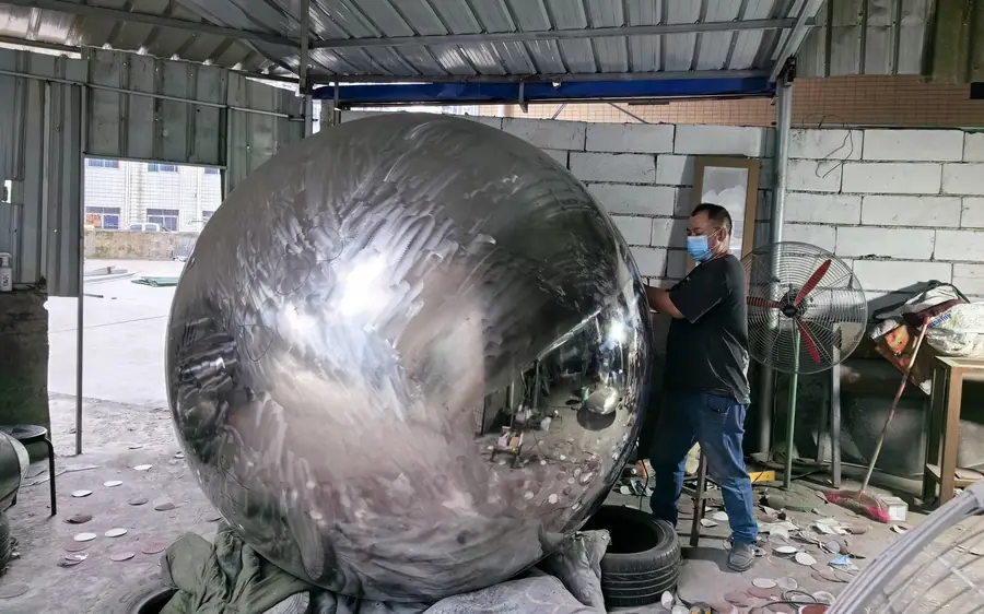 Analyze the production process and challenges of stainless steel sphere sculptures