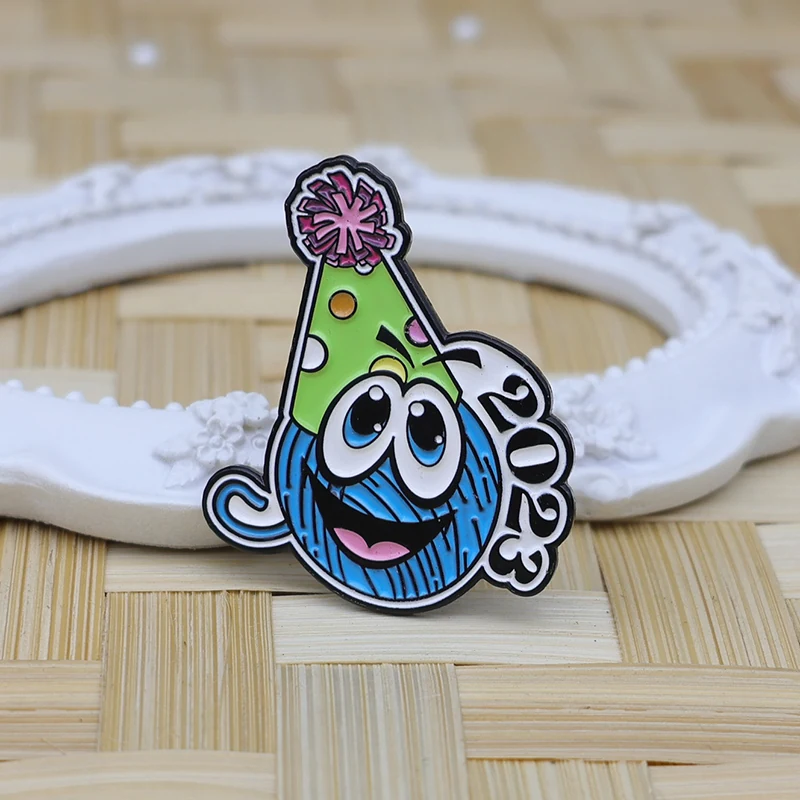 Close-up of the pin back and edge detail, showing the safety pin attachment on a black enamel lapel pin with a cute avatar