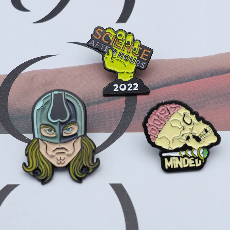 Shield lapel pin with engraved details and soft enamel colour, viewed from the front and side