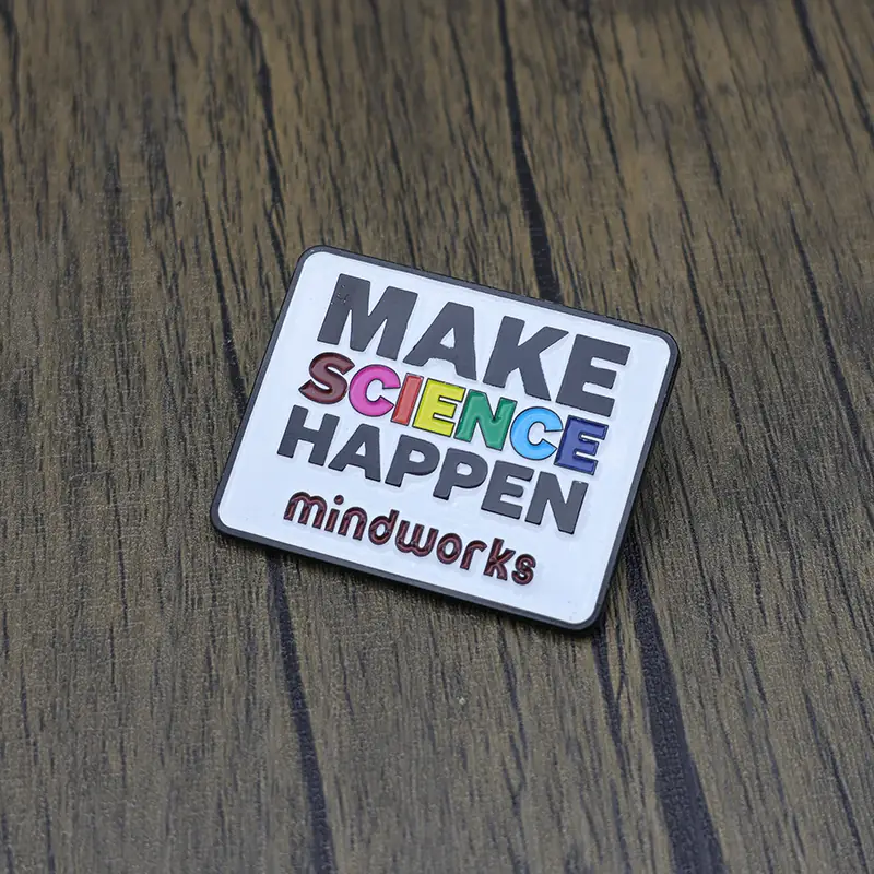 Close-up of the pin back and rubber stopper on a black metal lapel pin with engraved text