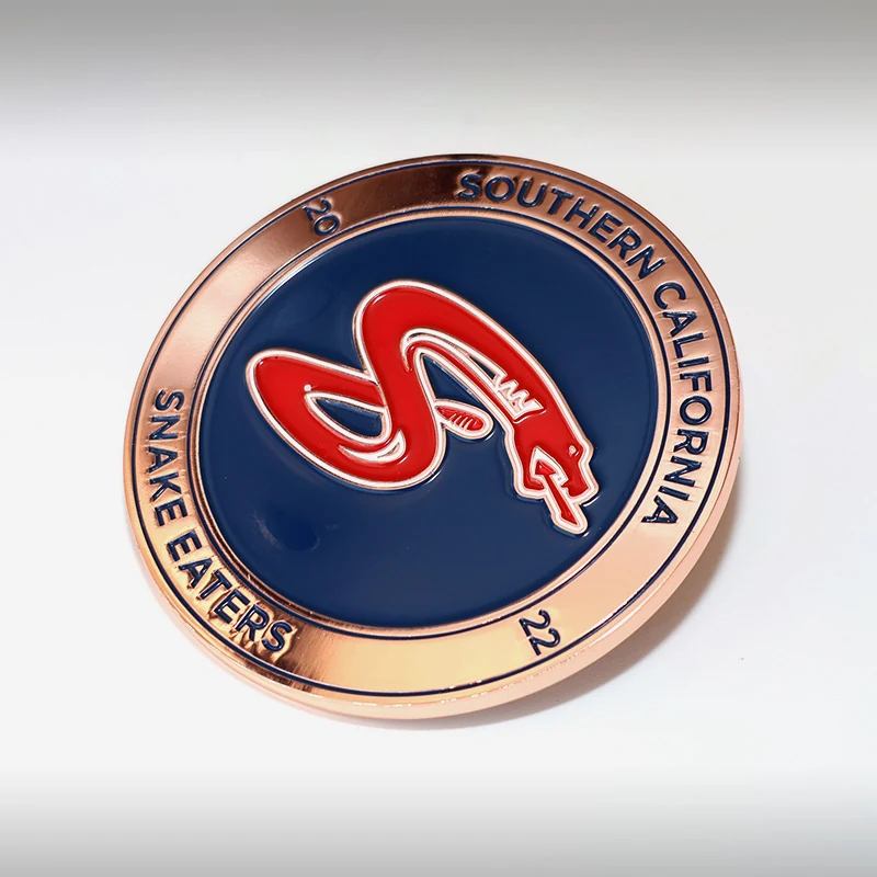 Custom polished gold snake challenge coin with red and black enamel on a round metal disc