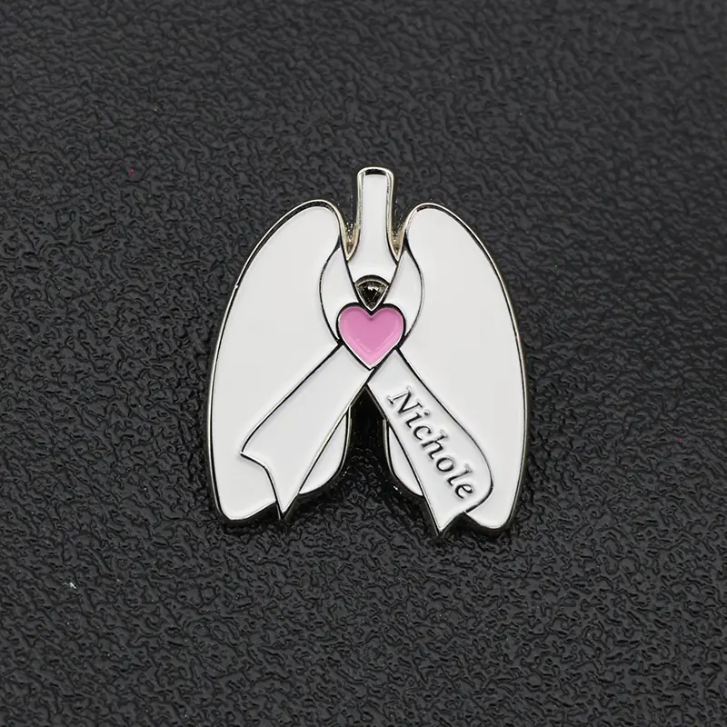Reverse side of the custom lapel pin showing the engraved name and safety pin attachment