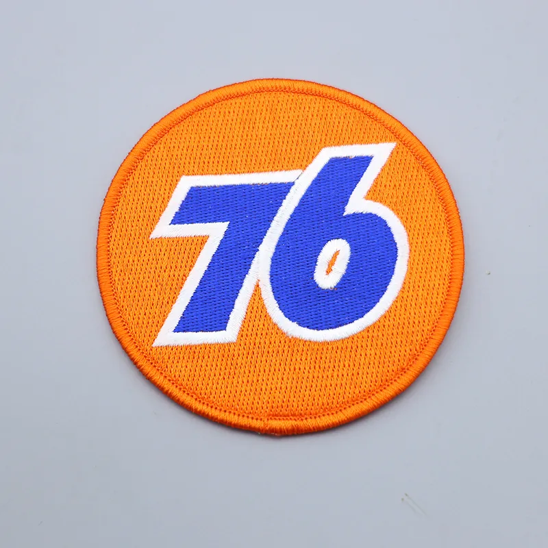 Custom embroidered number 76 patch in red and white with black outline on a black background
