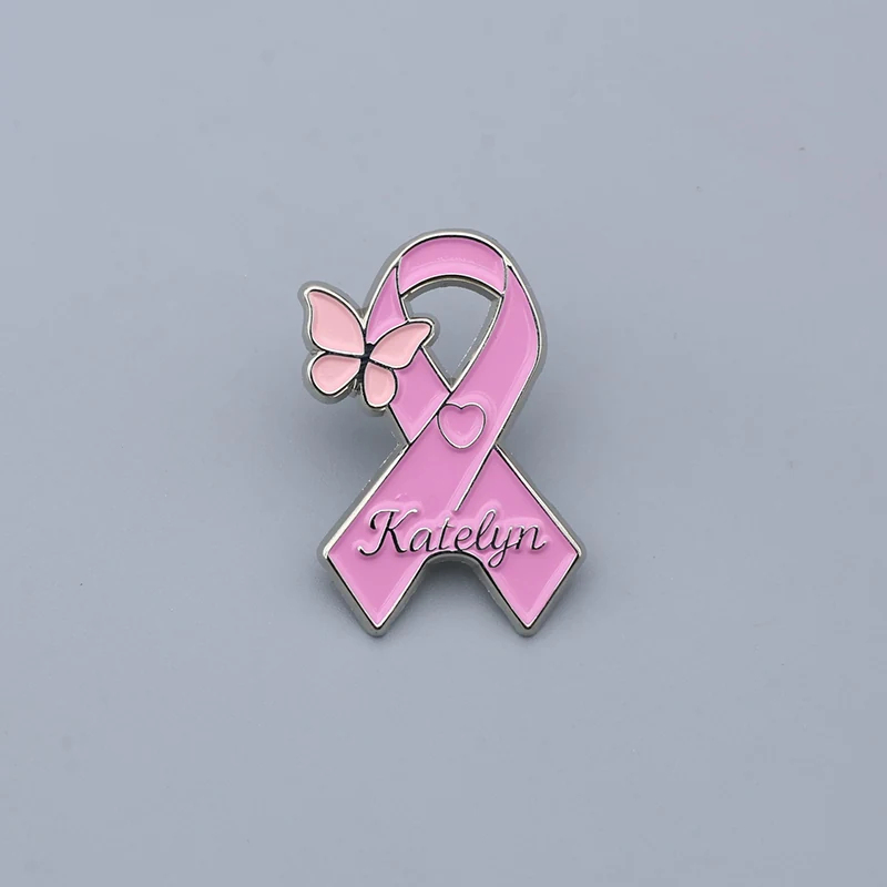 Custom pink ribbon butterfly enamel lapel pin with engraved name on the ribbon, polished metal finish, worn on a jacket