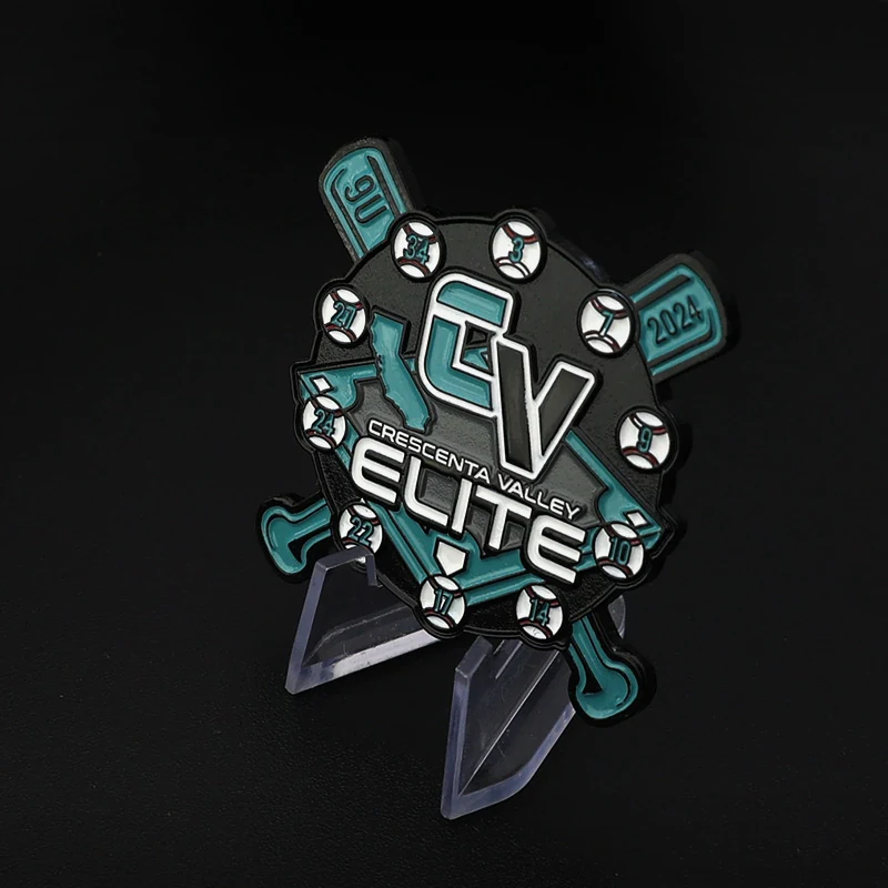 Close-up of black metal lapel pin showing soft enamel colour and die struck detail, with safety clasp