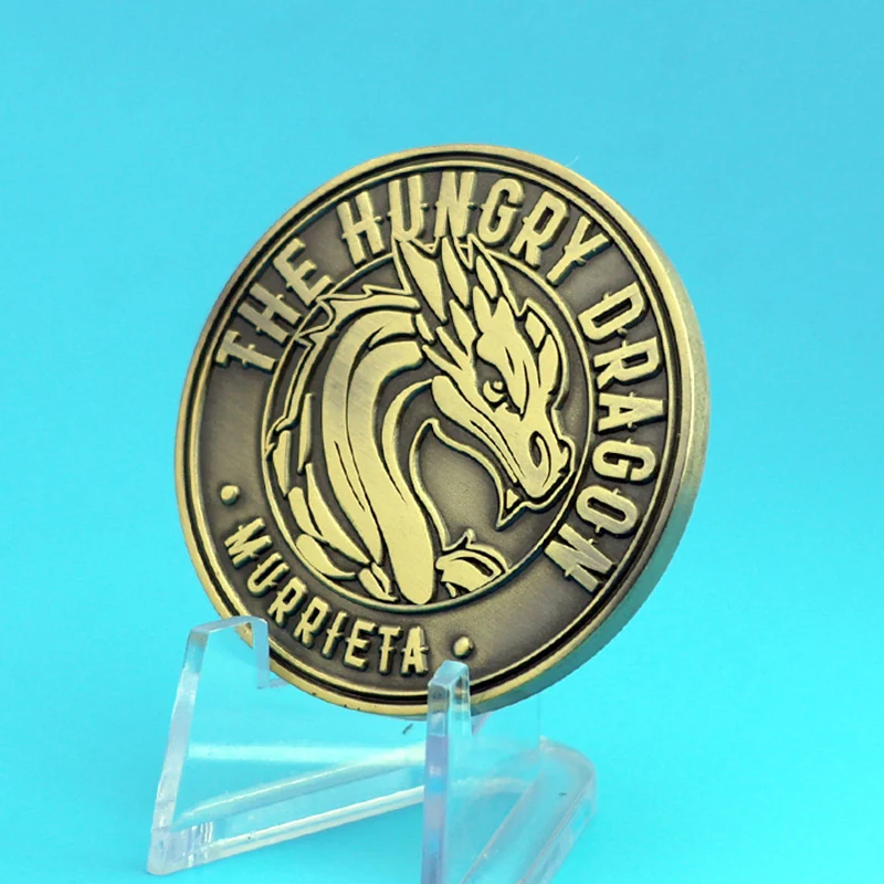 Dragon head challenge coin on a white background with a split ring attachment