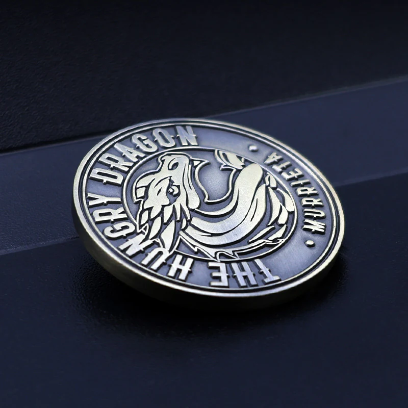 Close-up of a 3D die struck dragon head challenge coin in antique brass finish with detailed facial features and textured scales