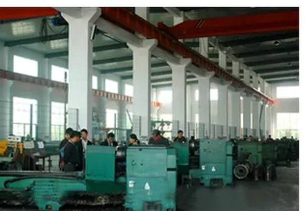 Lathe section with operators turning pump shafts and impellers