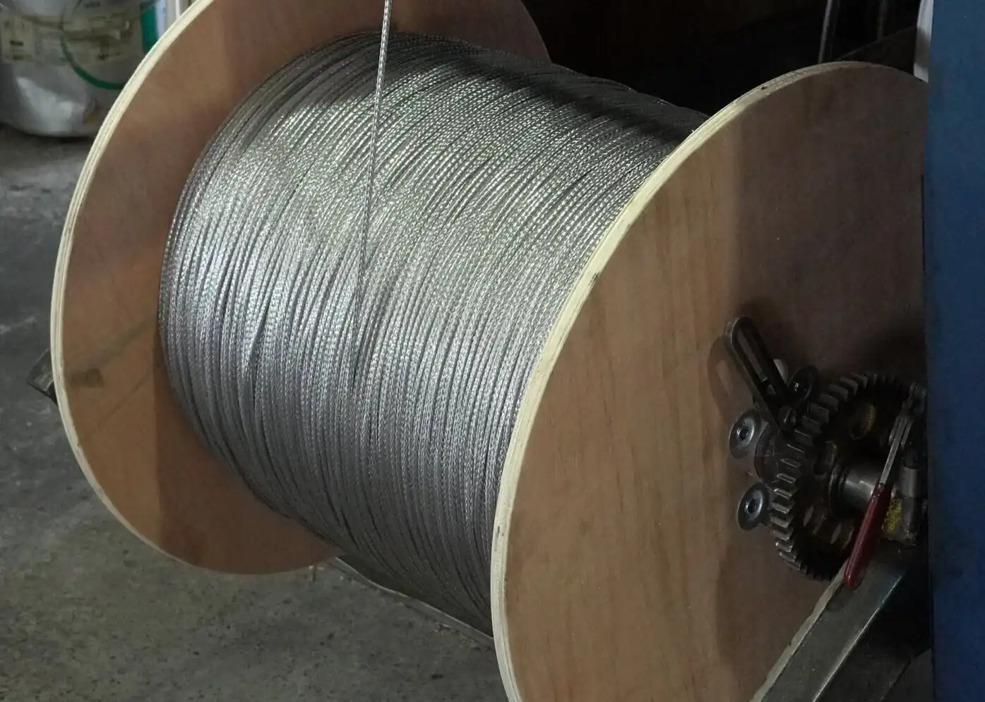 Braiding wire on a wooden reel beside the braiding machine