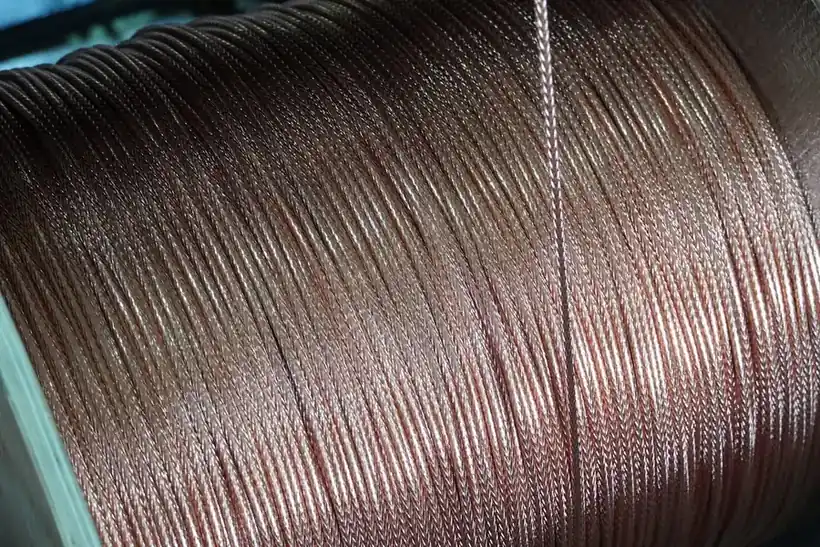 Copper wire spooled on a factory reel under workshop lighting
