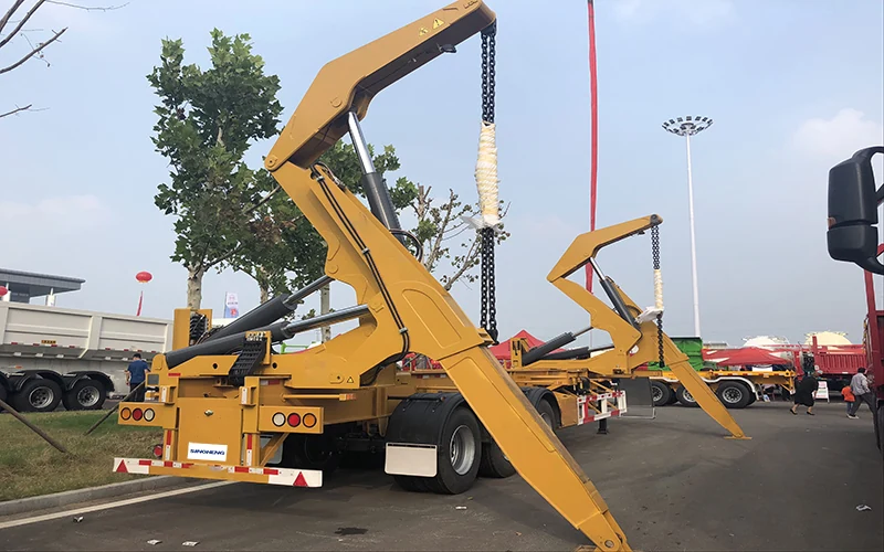 SINOHENG container side loader semi-trailer lifting a shipping container from the ground