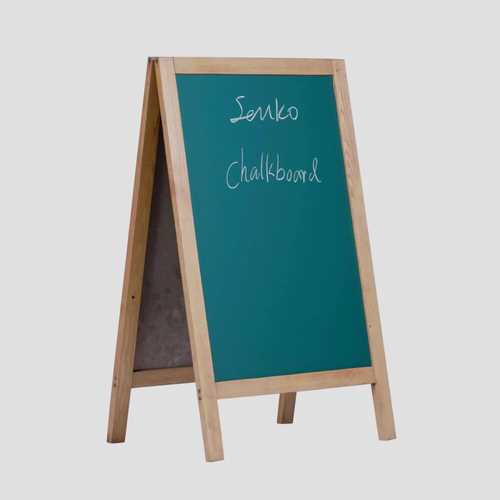 A frame wooden green chalkboard standing open with chalk writing on the green panel