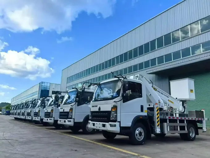 Aerial platform trucks parked alongside the workshop before shipment
