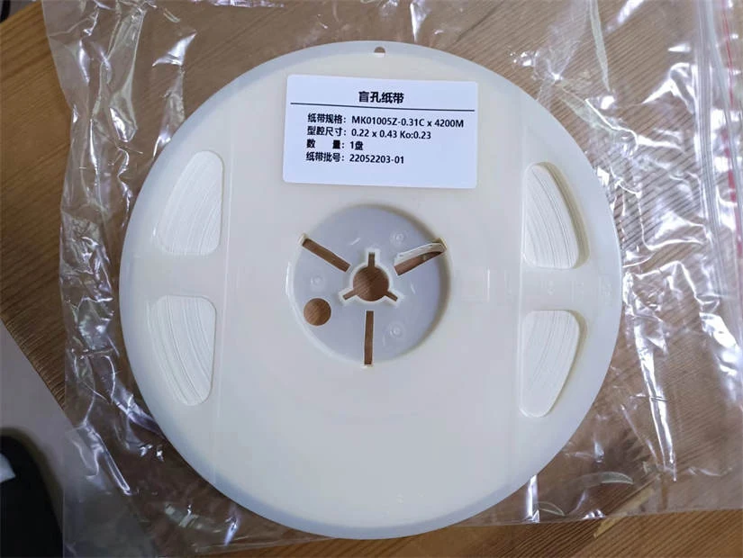 Sample roll of pre-punched paper carrier tape ready for testing in an SMT feeder