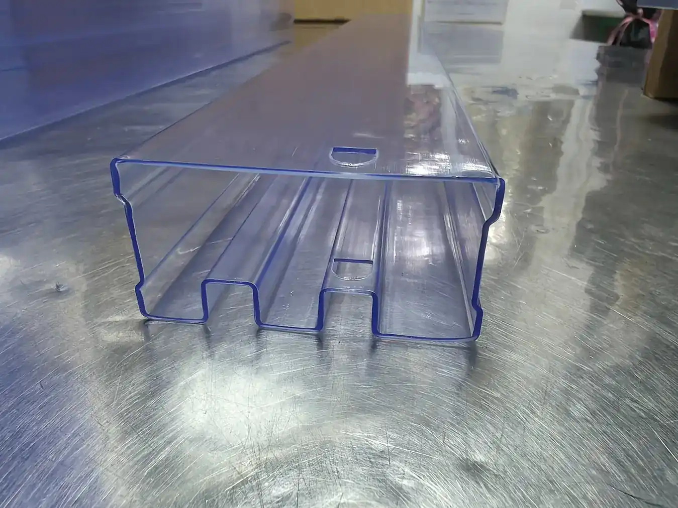 Translucent blue extruded plastic profile with internal channels lying