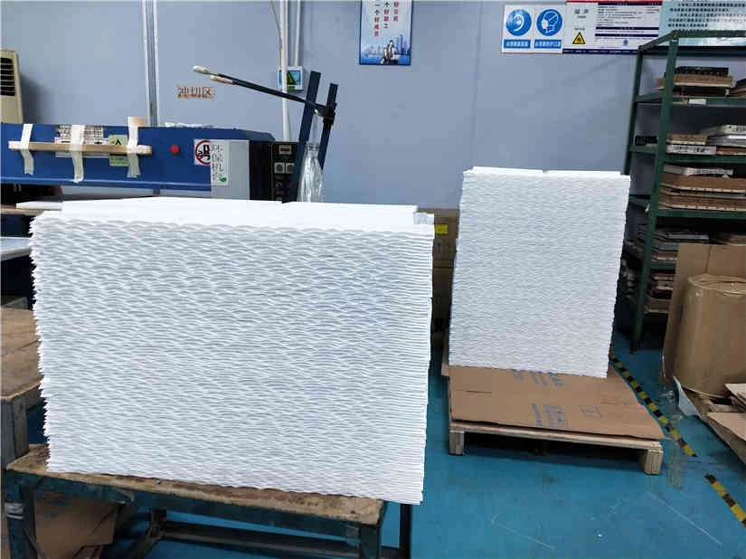 Stacks of white textured panels on a pallet