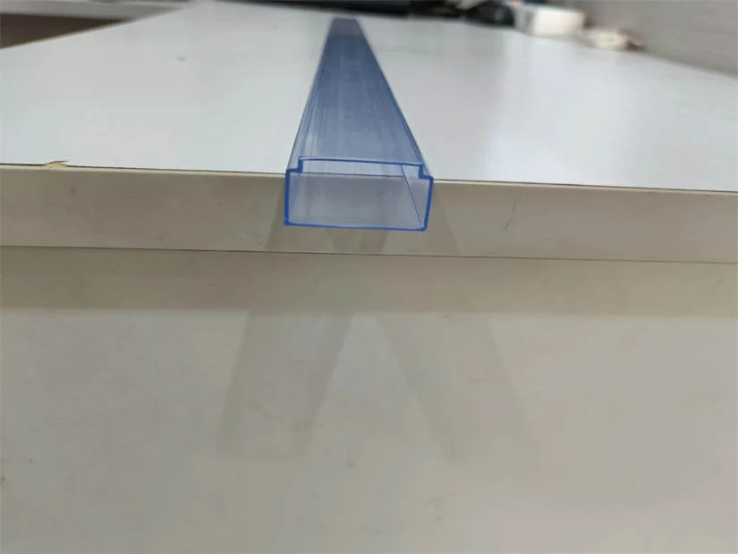 Translucent blue-tinted plastic U-channel extrusion profile lying