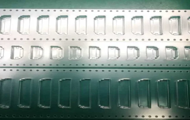 Rows of stamped metal components on carrier strips laid out