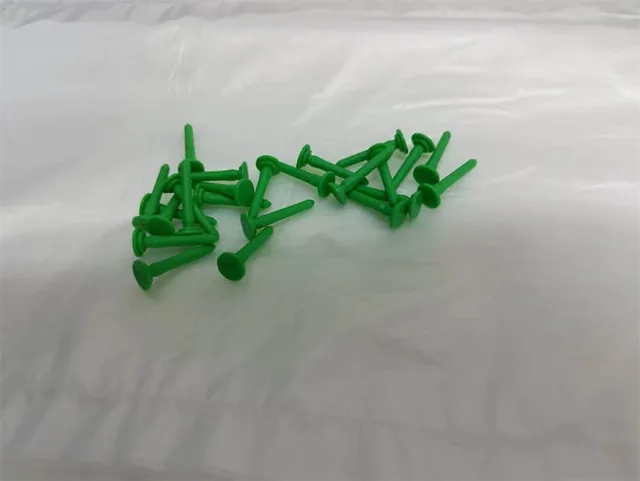 Plastic end pins being inserted into a tube end with a drill hole