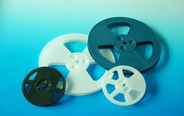 Blue plastic reels with carrier tape wound around them, ready for packaging