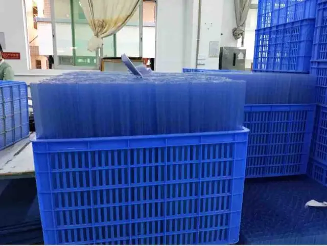 Blue plastic crates stacked in a workshop, filled