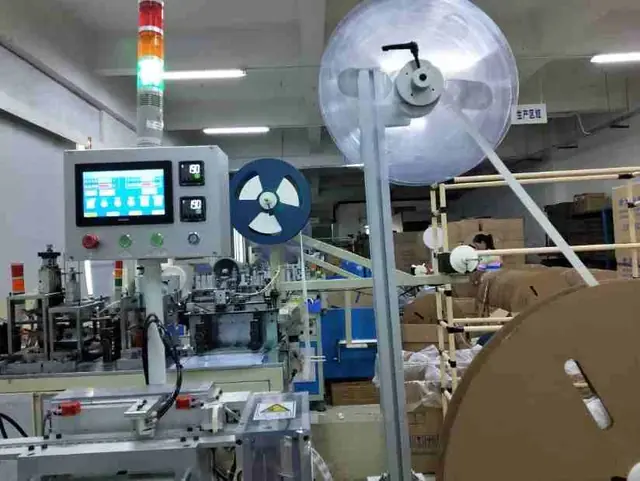 Industrial machine with a digital touchscreen control panel and large spools of material