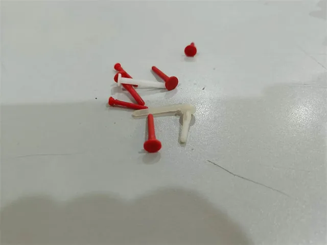 Plastic end pins and nails in various sizes and colors arranged in a tray