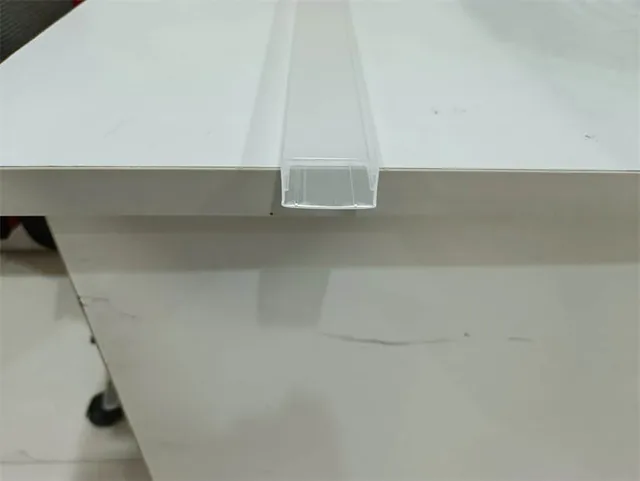 Translucent U-shaped plastic extrusion profile lying across the edge