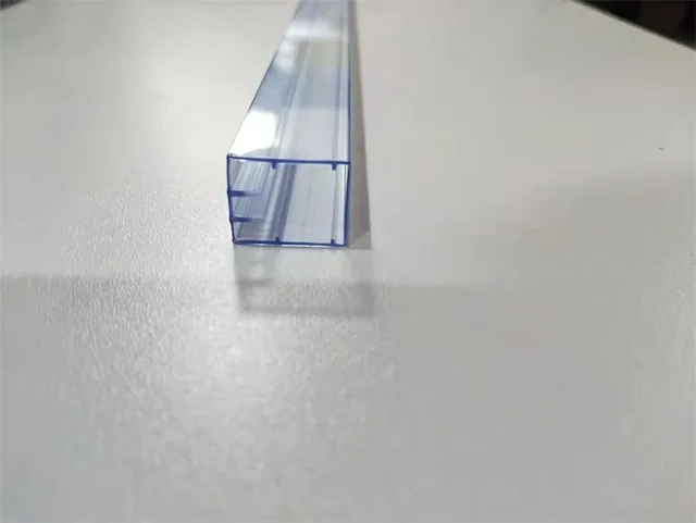 Translucent blue-tinted plastic U-channel extrusion profile lying