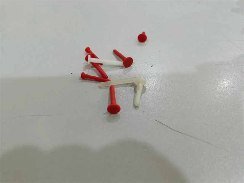 Plastic end pins and nails in various sizes and colors arranged in a tray