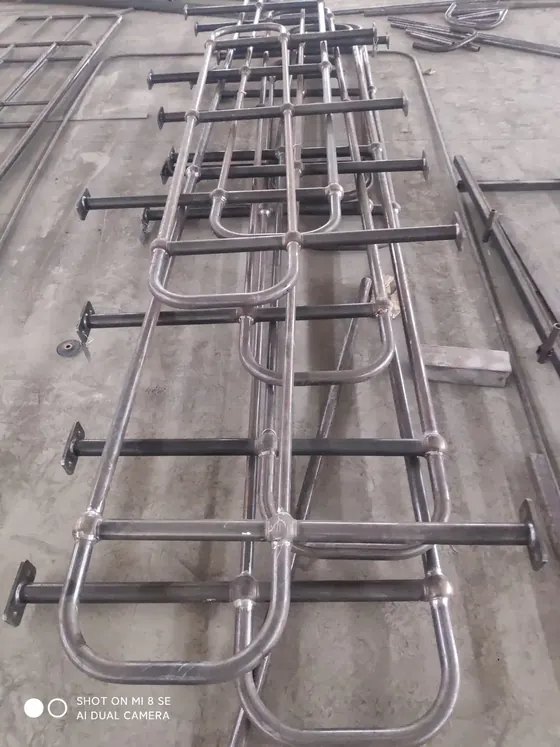 Ball joint stanchions and handrail tubes laid out on the workshop floor before galvanizing