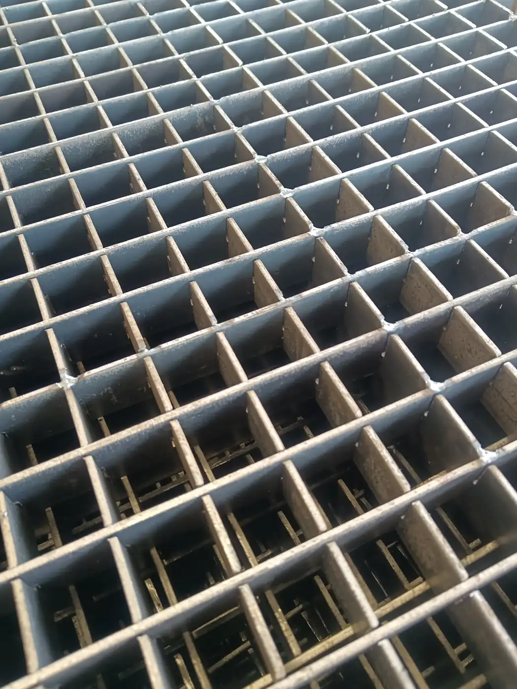 Close view of press locked steel grating showing the flush joint between bearing bar and cross bar