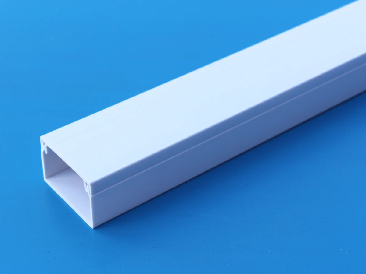 White PVC trapezoid cable trunking length on a blue background