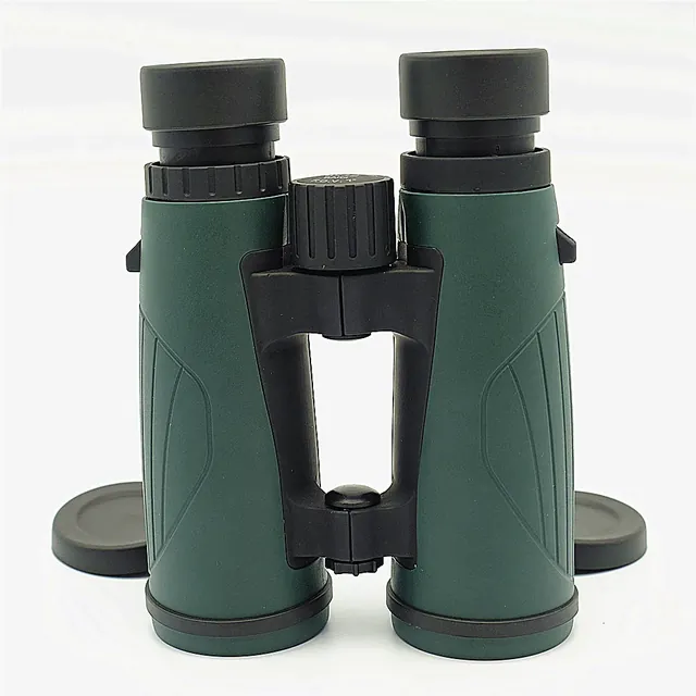 Green and black binoculars viewed from the back with lens caps on a white background