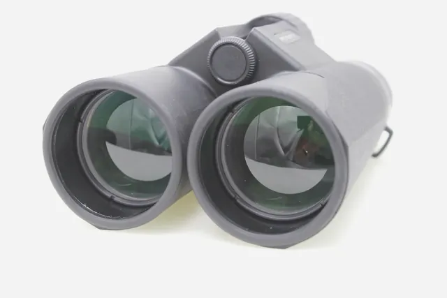Front view of a pair of grey binoculars with green coated lenses
