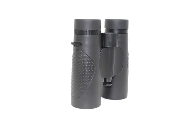 A pair of black compact binoculars with textured rubber grip standing upright on a white background